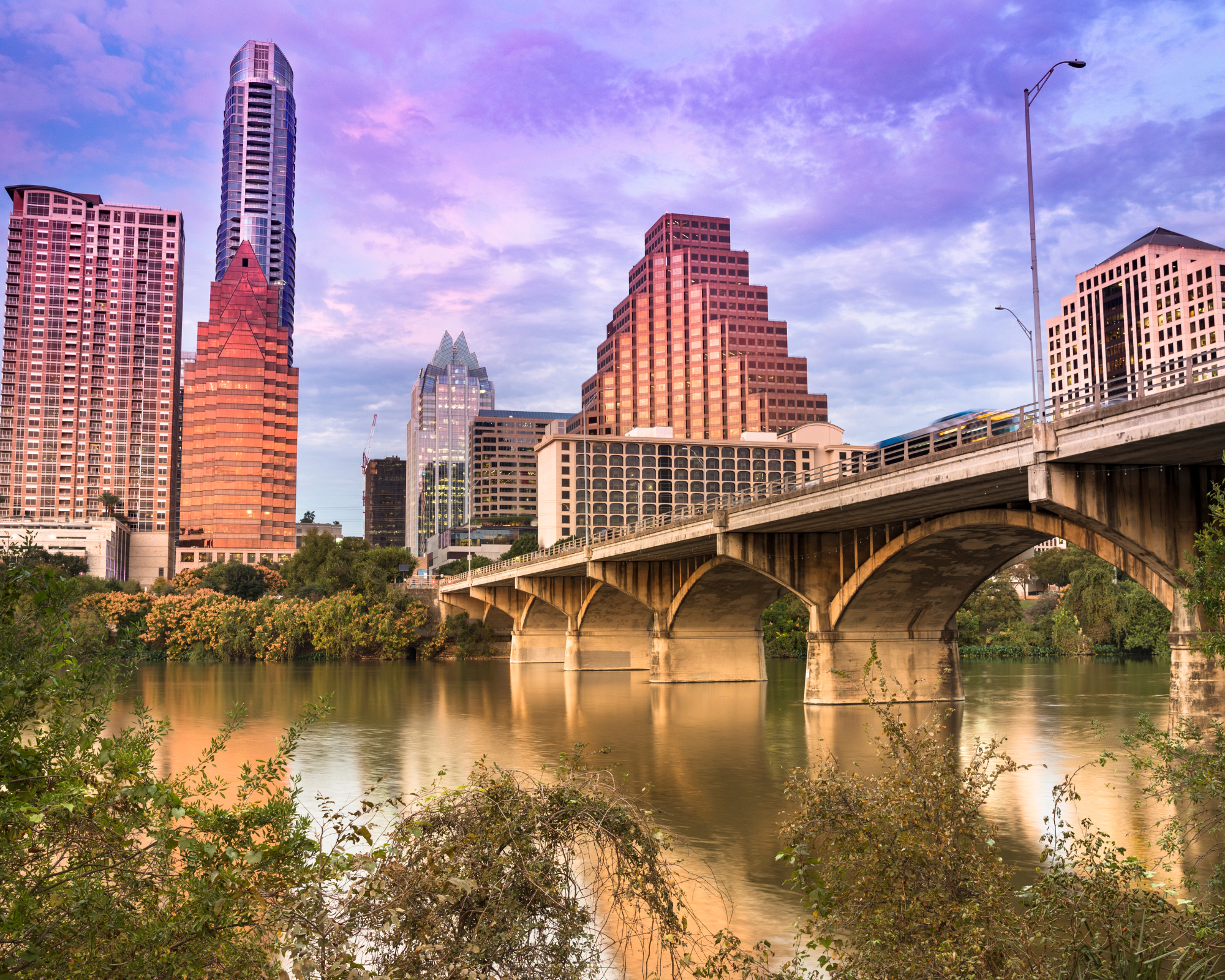 A bridge over water with buildings in the background.