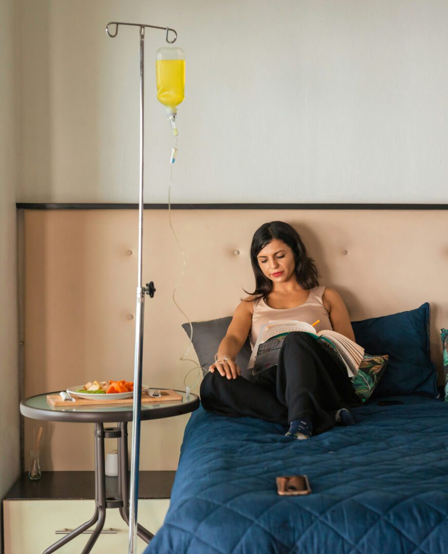 A woman sitting on top of a bed reading.