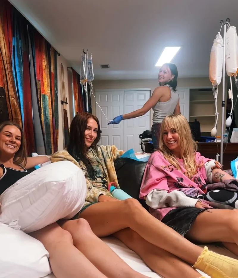 Friends relaxing together with IVs while a nurse checks on the group