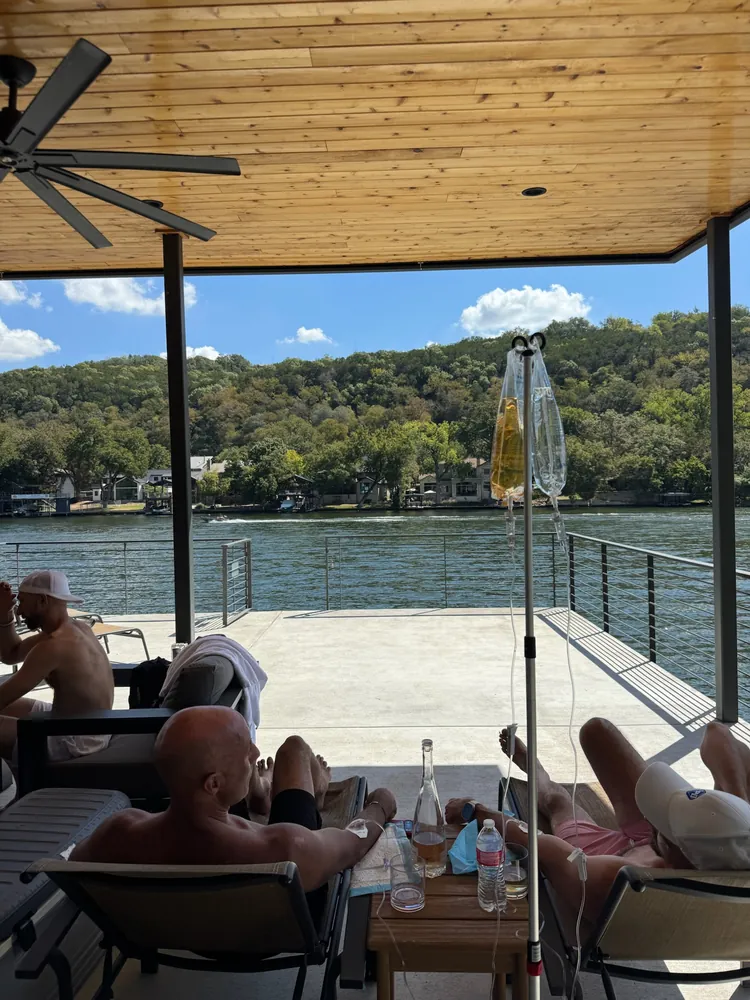 Guys relaxing with IVs on a covered lake house patio